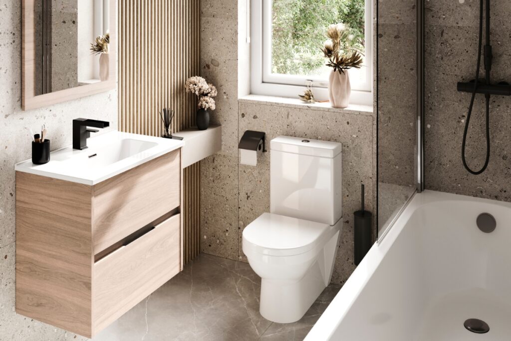 Full view of a renovated bathroom with a light wood floating vanity, close-coupled toilet, and a bathtub under a window.